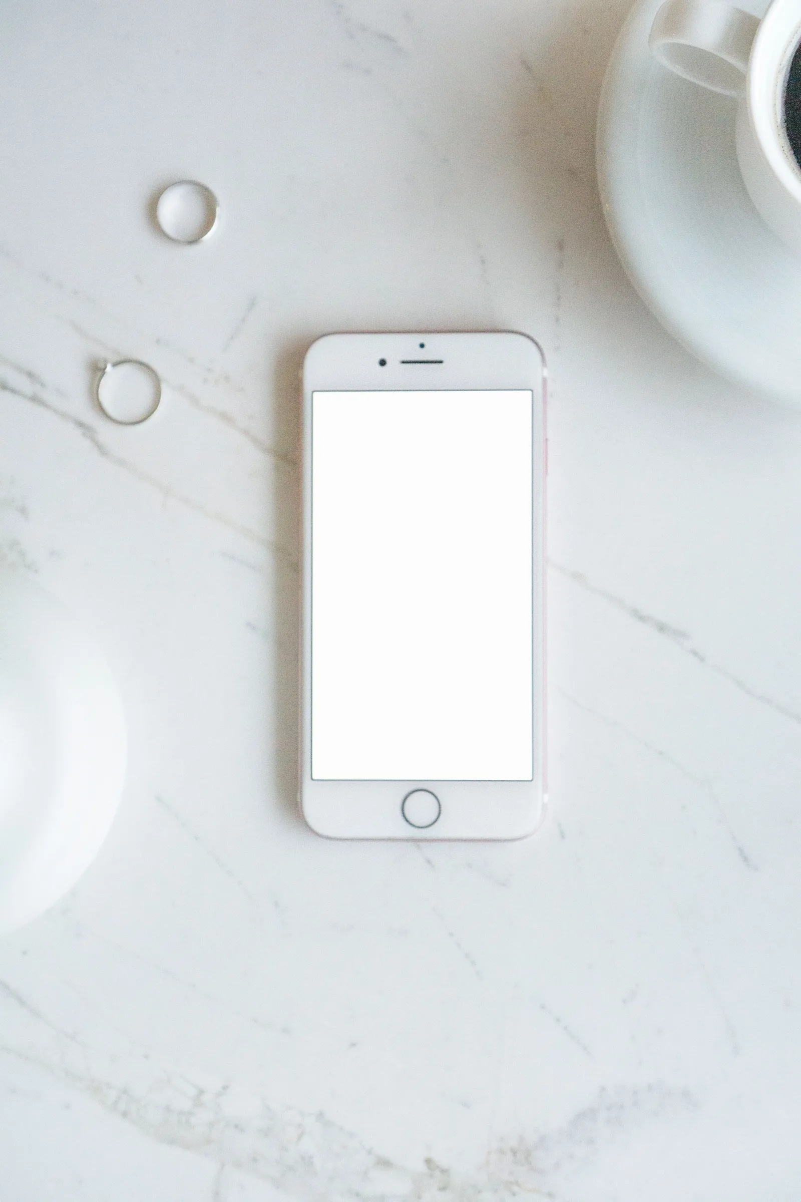 Smartphone neben einer Kaffeetasse auf einem Tisch